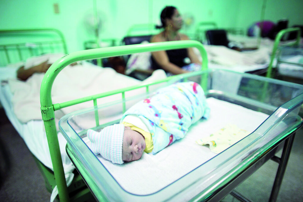 A new born baby rests beside his mother Dailyn Fleite (L), 29, at the Ana Betancourt de Mora Hospital in Camaguey, Cuba, June 19, 2015. The World Health Organization on Tuesday declared Cuba the first country in the world to eliminate the transmission of HIV and syphilis from mother to child. Picture taken June 19, 2015. REUTERS/Alexandre Meneghini