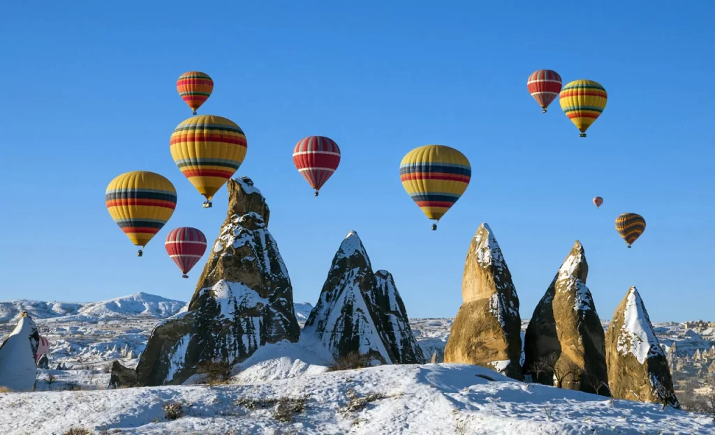 Cappadocia: Hot Air Balloons Over Snow-Covered Valleys. 